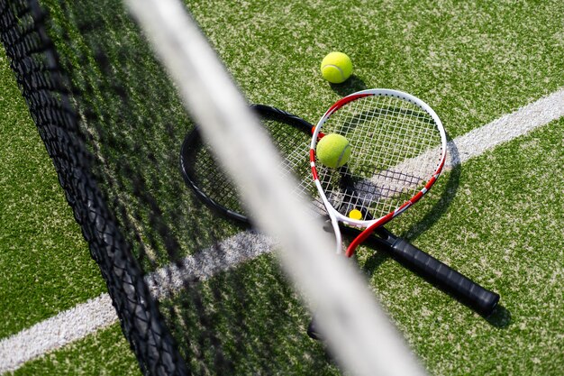 Una raqueta de tenis y una pelota de tenis nueva en una cancha de tenis recién pintada