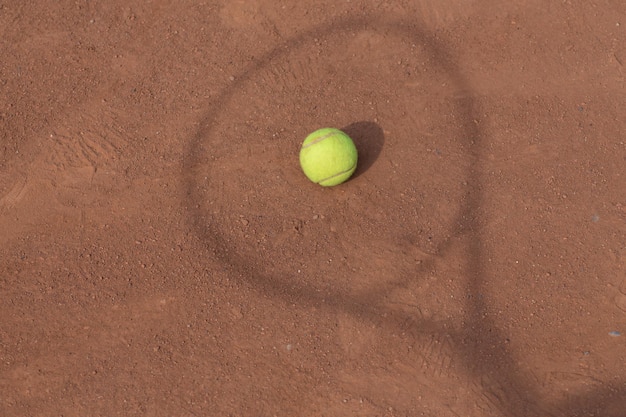 Raqueta de tenis y pelotas en la cancha de tierra batida