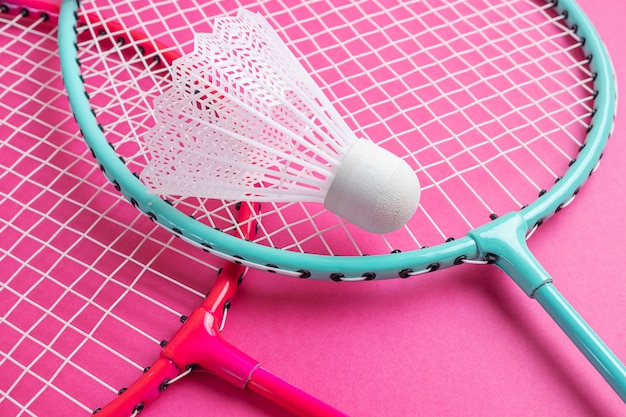 Foto raquetas de bádminton y volante en un rosa brillante.