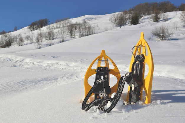 Raquetas de nieve plantadas en la nieve en la montaña bajo un cielo azul