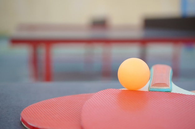 Raquetas y pelota en la mesa de ping pong en el patio de deportes al aire libre. Concepto de deporte activo y entrenamiento físico