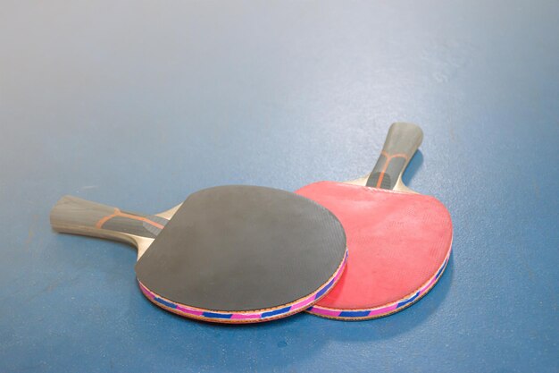 Raquetas de ping pong y pelotas en la mesa.