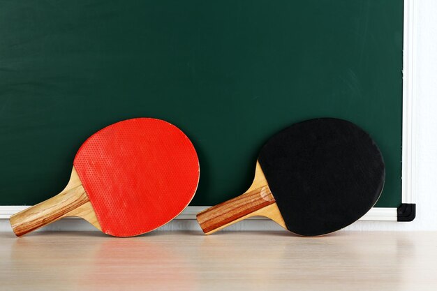 Foto raquetas de tenis de mesa sobre fondo de pizarra