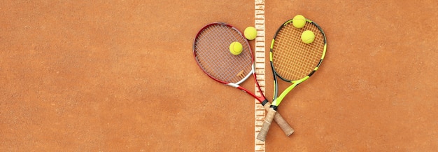 Raquetas de tenis con pelotas de tenis en tierra batida