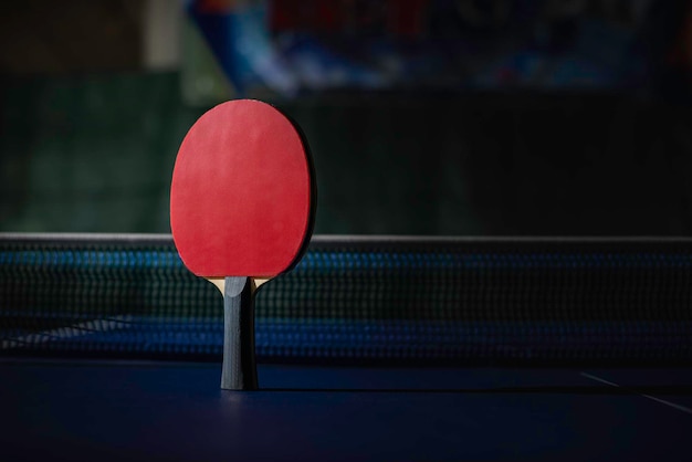 Raquete de tênis de mesa na mesa azul de pingue-pongue