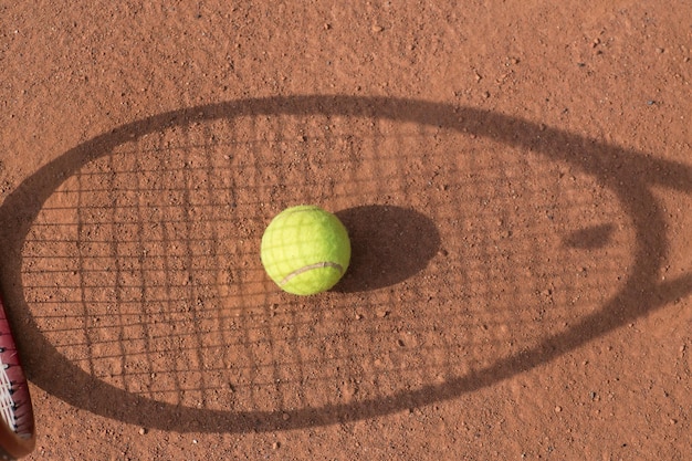 Raquete e bolas de tênis na quadra de saibro