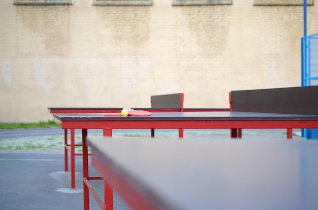 Raquetes e bola na mesa de pingue-pongue no pátio de esportes ao ar livre esportes ativos e conceito de treinamento físico