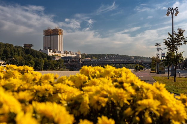 Rascacielos adornado con estructura dorada en el techo y cama de flores de color amarillo brillante Moscú Rusia