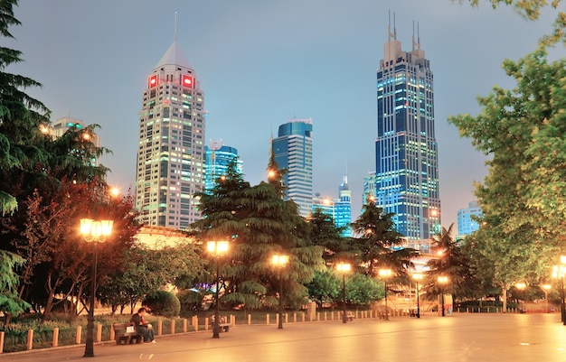 Rascacielos y calle urbanos en Shangai en la noche