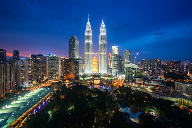 Rascacielos de la ciudad de Kuala Lumpur y parque espacial verde con agradable puesta de sol en el cielo