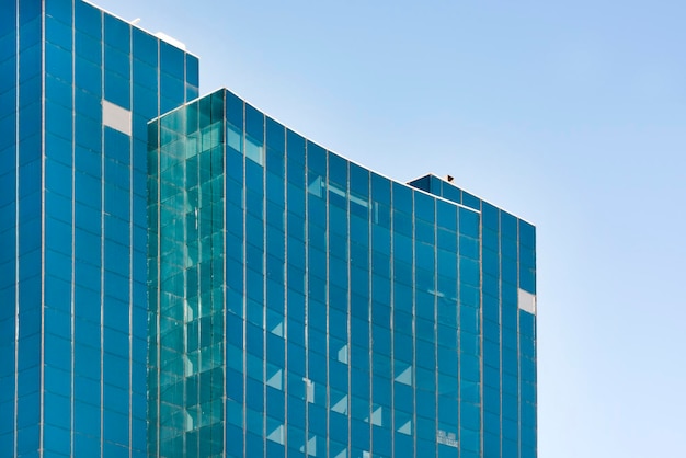 Rascacielos moderno con fachadas de cristal azul sobre un fondo de cielo