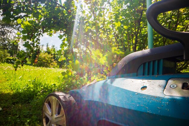 Rasenbeweger auf grünem Gras im modernen Garten oder Hinterhof Rasenhackmaschine Gartenpflegewerkzeuge und -geräte Rasenbeschneidungsprozess