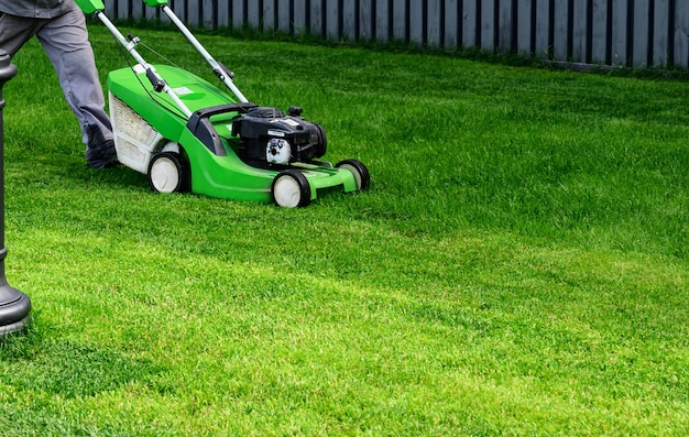 Rasenmäher auf grünem Gras im modernen Garten Maschine zum Schneiden von Rasenflächen