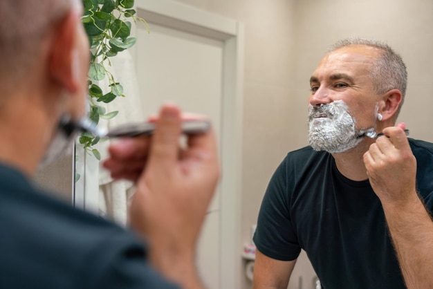 Rasieren von Bart und Schnurrbart Mann mit Rasiermesser, um Haare auf seinem Gesicht loszuwerden