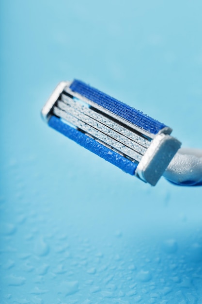 Rasierklingen auf blauem Hintergrund mit Eiswassertropfen