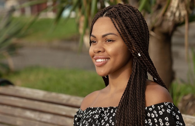 Rastas. Retrato de una hermosa joven afroamericana con peinado de coletas sonriendo.