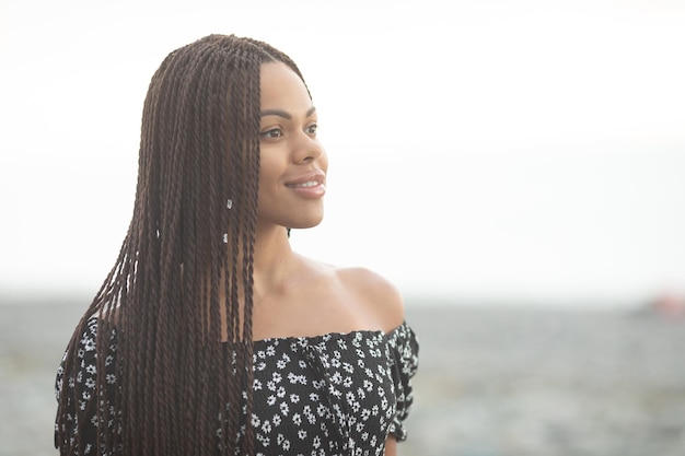 Rastas. Retrato de una hermosa joven afroamericana con peinado de coletas sonriendo.