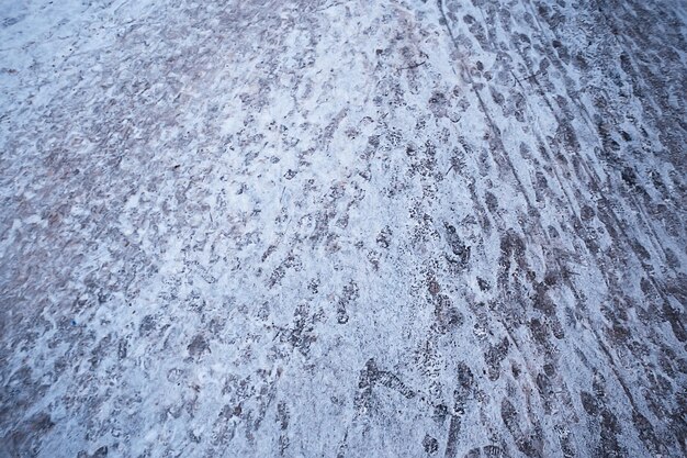 rastrea la nieve asfáltica, el hielo, las huellas de las personas de los zapatos en la nieve, el clima de remoción de nieve