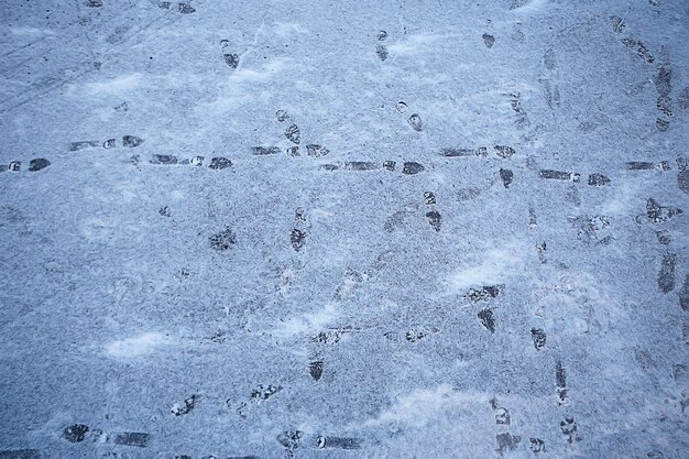 rastrea la nieve asfáltica, el hielo, las huellas de las personas de los zapatos en la nieve, el clima de remoción de nieve