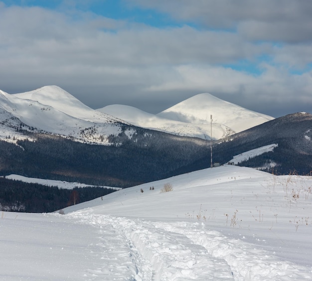 Rastro de trenó e pegadas no topo da montanha de inverno