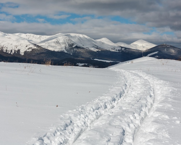Foto rastro de trenó e pegadas no topo da montanha de inverno