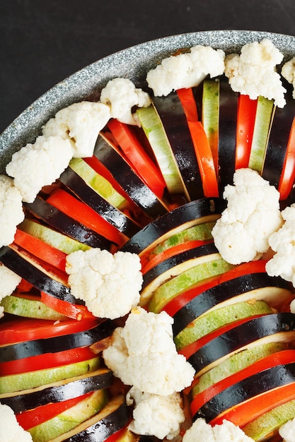 Ratatouille-Teller mit frischem Gemüse in einer Pfanne auf dunklem Hintergrund. Traditionelles französisches vegetarisches Gericht