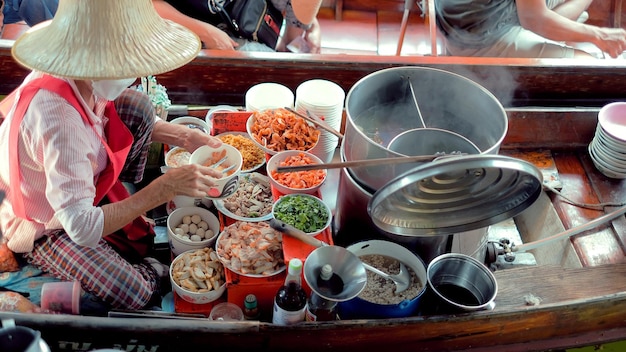 Ratchaburi Tailandia 15 de abril de 2022 Vendedores que venden fideos tailandeses en barcos Antiguo destino de viaje de Tailandia Damnoen saduak flating market Ratchaburi Tailandia