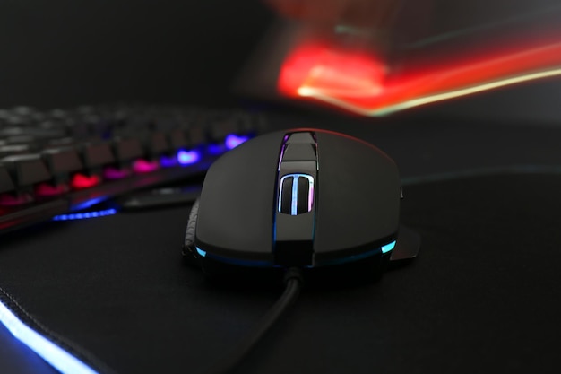 Rato de computador e teclado RGB em close de fundo escuro
