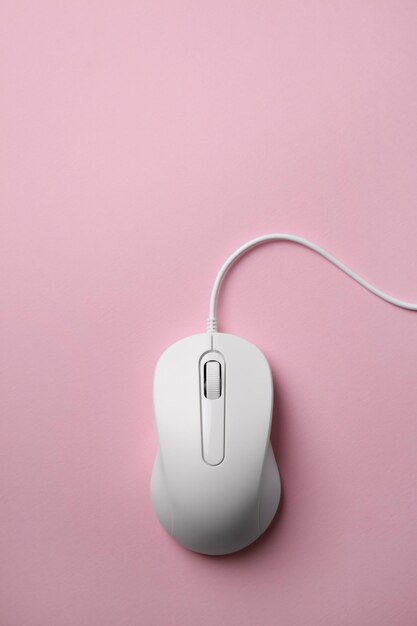 Un ratón con cable en fondo rosa vista superior