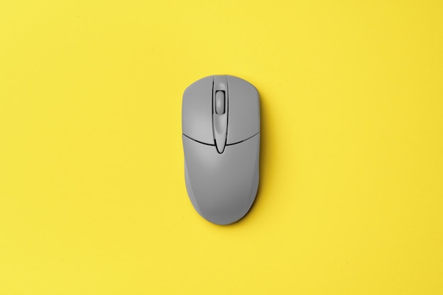 Ratón de computadora gris sobre amarillo