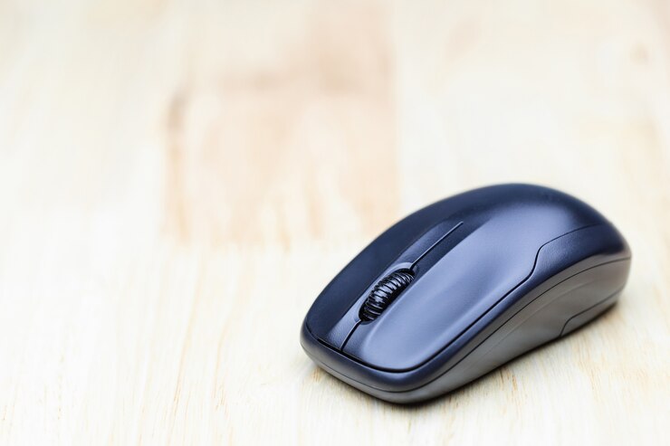 Ratón inalámbrico de computadora en la mesa de madera para el diseño