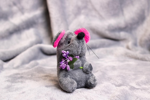 Foto ratón de juguete de peluche gris sobre fondo gris
