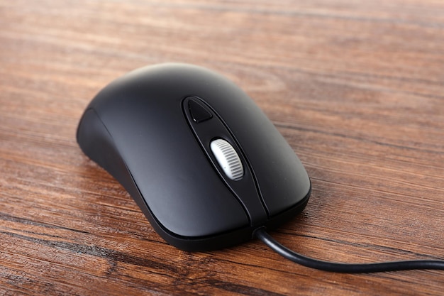 Ratón de ordenador con cable sobre fondo de madera
