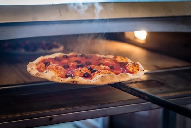 Foto rauch von frisch gebackener pizza in einer kommerziellen küche