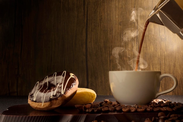 Rauchigen Kaffee Schokolade Donut und Kaffeebohnen auf Holztisch gießen