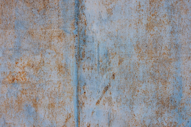 Raue hellblaue abblätternde Farbe auf verrosteter flacher Blechoberfläche