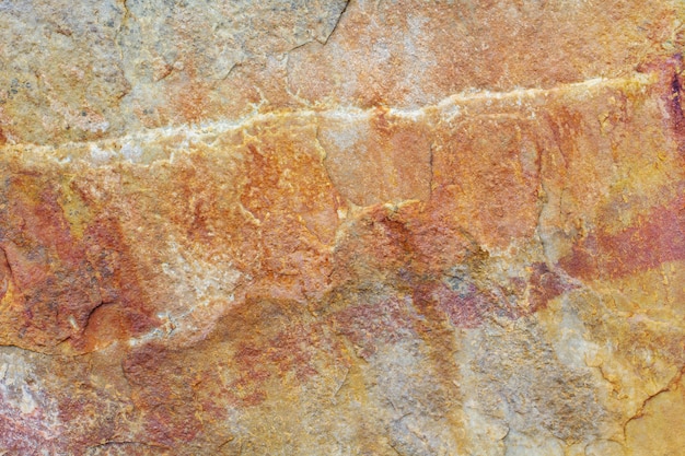 Raue Naturstein-Hintergrundtextur mit rostigen Braun- und Grautönen