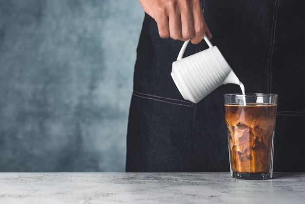 Raum Eiskaffee mit Hand gießen Milch Essen Hintergrund