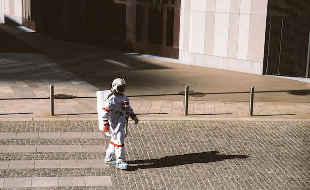 Raumfahrer in einer futuristischen Station. Astronaut mit Raumanzug zu Fuß in einem Stadtgebiet walking