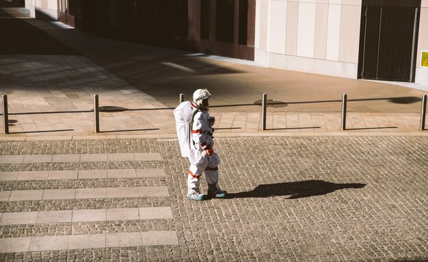 Raumfahrer in einer futuristischen Station. Astronaut mit Raumanzug zu Fuß in einem Stadtgebiet walking