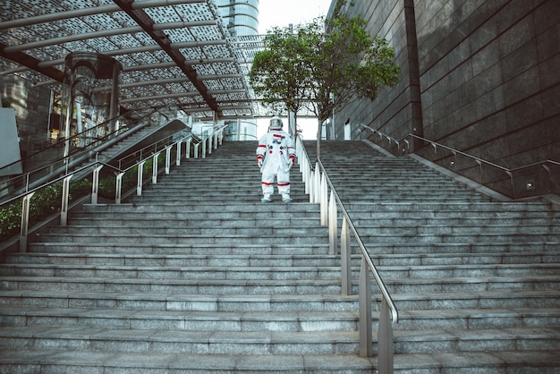 Raumfahrer in einer futuristischen Station. Mann mit Raumanzug, der in einem Stadtgebiet spaziert