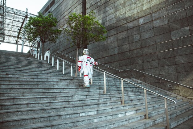 Raumfahrer in einer futuristischen Station. Mann mit Raumanzug, der in einem Stadtgebiet spaziert