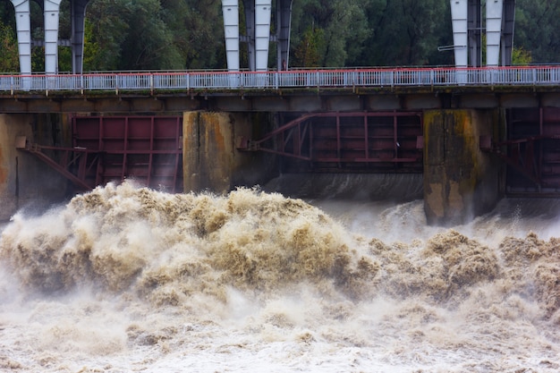 Rauschende Schmutzwasserströme am Damm im Frühjahr