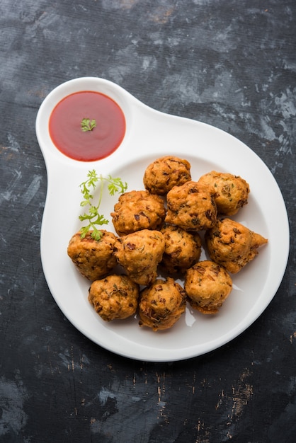 Rava Bhajj oder Bhajiya, auch bekannt als Suji Pakoda oder Grieß Pakora, serviert mit Tomatenketchup. selektiver Fokus