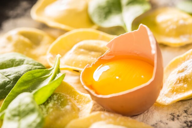 Ravioles crudos con huevo en harina, musrooms y espinacas. Cocina sana italiana o mediterránea.