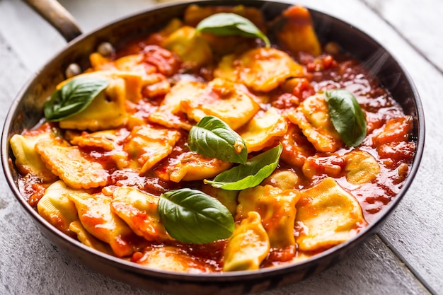 Ravioles de pasta de comida italiana o mediterránea de salsa de tomate y albahaca.