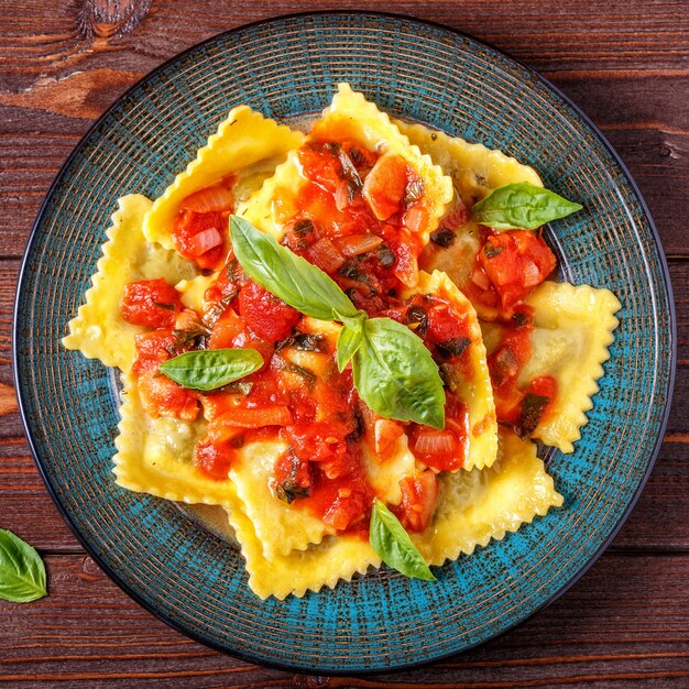 Ravioles con salsa de tomate y albahaca sobre oscuro