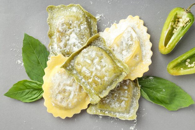 Ravioli cru com especiarias em fundo cinza claro