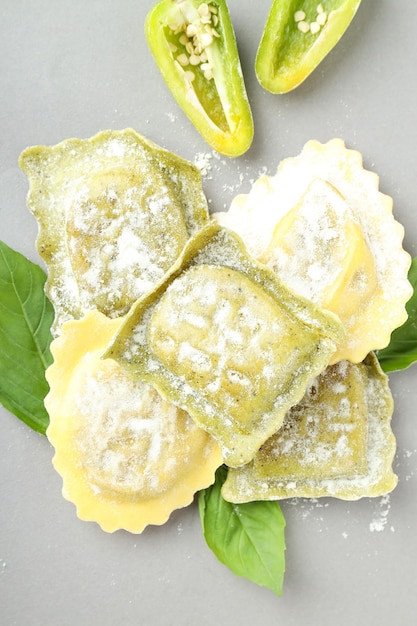 Ravioli cru com especiarias em fundo cinza claro