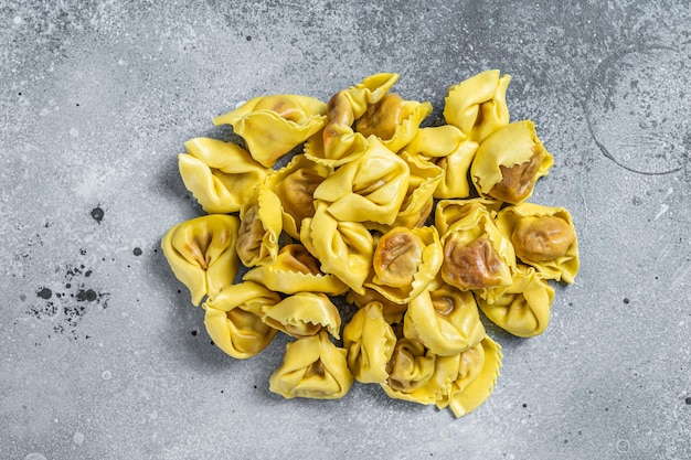 Ravioli cru cru com mussarela e tomate. Fundo cinza. Vista do topo.